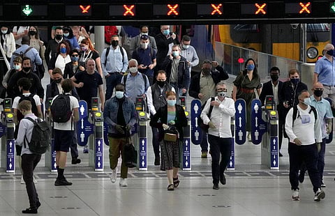 People wear face masks to curb the spread of coronavirus during the morning rush hour at Waterloo train station in London. (Photo | AP)