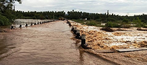 Water flows over a low-level bridge across the Palar river during the recent heavy rains