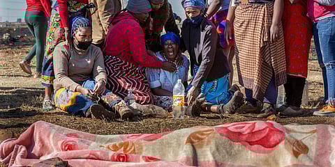 Family members mourn next to the body of a fifteen-year old boy who was allegedly shot dead by taxi association members attempting to disperse looters in Johannesburg, July 14, 2021. (Photo | AP)