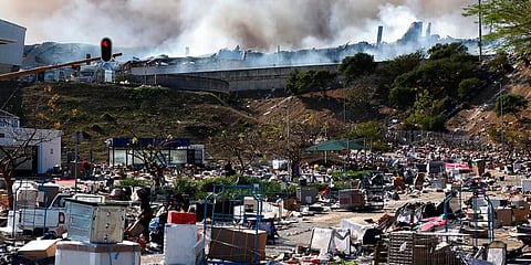A factory burns in the background while empty boxes litter the foreground from looted goods being removed, on the outskirts of Durban, South Africa, Wednesday, July 14, 2021. (Photo | AP)