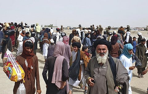 Pakistan army soldiers stand guard as stranded people gather near the Pakistan Afghan border crossing following fighting between Afghan security forces and Taliban. (Photo | AP)