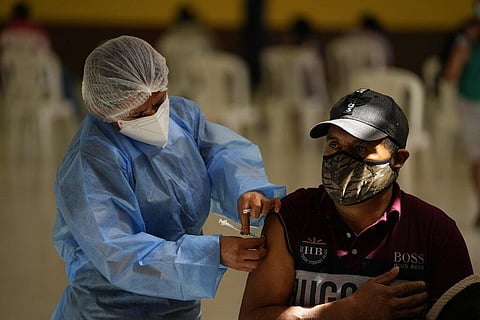 A healthcare worker administers a dose of the Moderna COVID-19 vaccine at a vaccination center in San Juan Sacatepequez, Guatemala