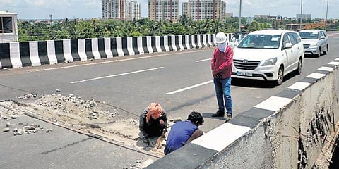 Labourers repairing the damaged portion of Khandagiri flyover’s expansion joint on Saturday. (Photo | Irfana, EPS)