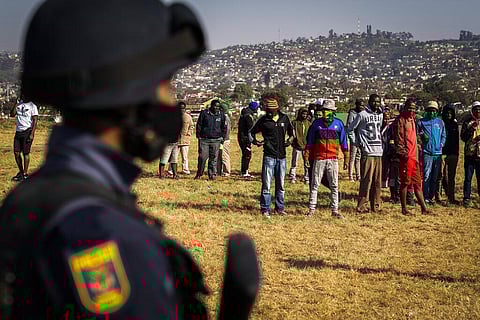 An armed policeman patrols as Police Minster Bheki Cele visits Phoenix, a neighbourhood severely affected by unrest and racial tensions near Durban. (Photo | AP)