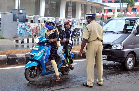 File photo of a police officer stopping a woman who was travelling with her two children despite the travel ban imposed as part of triple lockdown in Kochi | A Sanesh