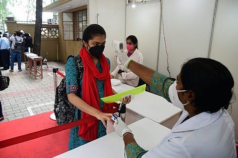 A student undergoing temperature check before entering the exam hall in Bengaluru. (Photo | Shriram BN, EPS)