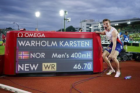Norway's Karsten Warholm celebrates in front of the scoreboard after running 46.70 seconds to set a new men's 400m hurdles world record at the Diamond League meeting in Oslo. (Photo | AP)