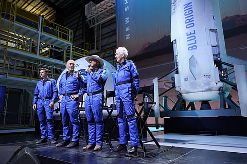 Oliver Daemen, from left, Mark Bezos, and Wally Funk, right, listen as Jeff Bezos makes comments after their flight experience. (Photo | AP)
