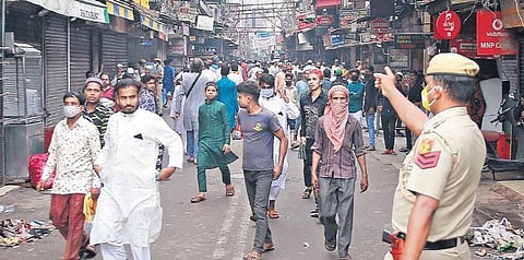 A policeman asking revellers to avoid crowding in Old Delhi. (Photo | Shekhar Yadav, Express)
