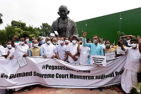 ongress, DMK and other parties MPs stage a protest near the Gandhi statue against Pegasus project. (Photo | PTI)