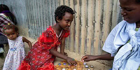 Elena, 7, left, plays a game of checkers using soda bottle tops with friend Hailemariam, 12, at a reception and day center for displaced Tigrayans in Mekele, in Ethiopia's Tigray region. (Photo | AP)