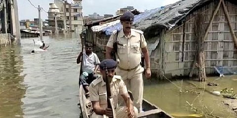 Policemen row a boat to the police station in Bihar's Ahiyapur. (Photo| ANI)