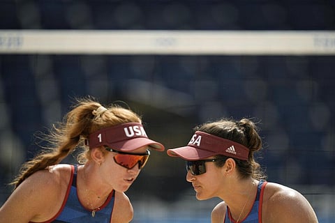 Kelly Claes, left, of the United States, and teammate Sarah Sponcil react during a women's beach volleyball match against Latvia at the 2020 Summer Olympics. (Photo | AP)