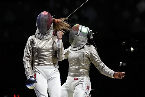 Manon Brunet of France, left, celebrates defeating Chadalavada Anandha Sundh Bhavani of India in the women's individual round of 32 Sabre competition. (Photo | AP)