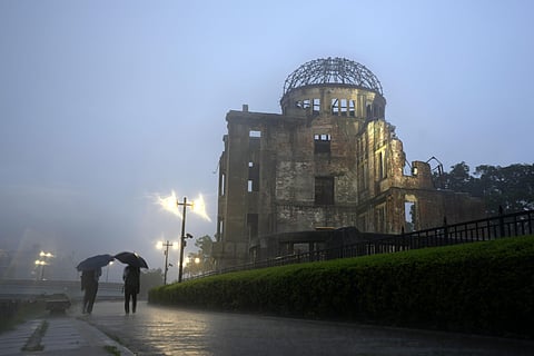 In this July 15, 2021, file photo, men walk in a heavy rain near the Atomic Bomb Dome in Hiroshima, western Japan. (Photo | AP)