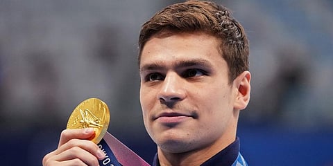 Evgeny Rylov of the Russian Olympic Committee poses with his gold medal for the men's 100-meter backstroke final at the 2020 Summer Olympics in Tokyo, Japan. (Photo | AP)