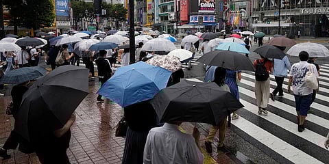 Morning commuters with umbrella cover a crosswalk in Tokyo. (Photo| AP)