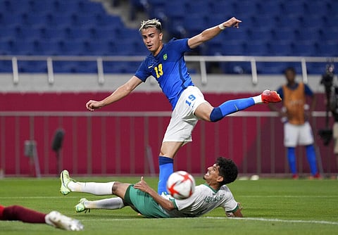 Brazil's Reinier, top, and Saudi Arabia's Abdulbasit Hindi battle for the ball during a men's soccer match at the 2020 Summer Olympics. (Photo | AP)
