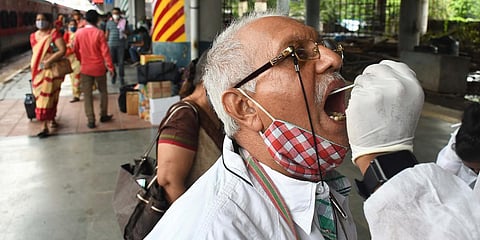 A healthcare worker takes a swab sample of a passenger during the COVID-19 test in Mumbai. (Photo| ANI)