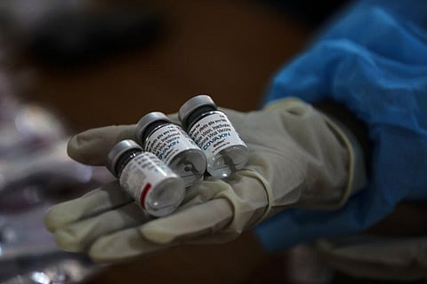 A health worker displays empty vials of COVAXIN at a vaccination center. (Photo | AP)