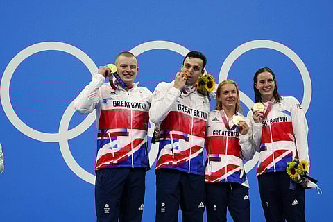 Britain mixed 4x100-meter medley relay team, Kathleen Dawson, Adam Peaty, James Guy and Anna Hopkin, poses after winning the gold medal at the 2020 Summer Olympics. (Photo | AP)