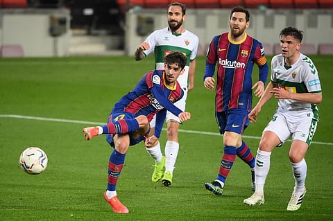 Barcelona's Francisco Trincao (L) kicks the ball in an attempt to score during the Spanish league football match against Elche CF at the Camp Nou stadium in Barcelona. (Photo | AFP)