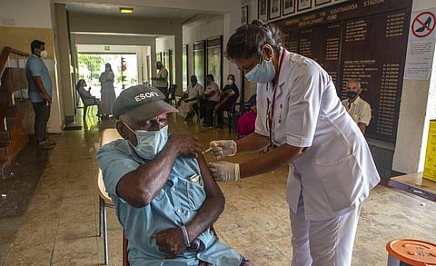 A Sri Lankan health worker administers the second dose of Covishield to an elderly man during a public vaccination drive in Colombo, Sri Lanka (Photo | PTI)