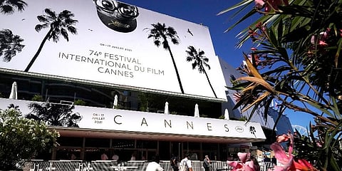 The Cannes Film Festival palace -- a squat, concrete construction dubbed 'the bunker' -- is draped in a poster featuring Lee, in oversize spectacles, peering between two palm trees. (Photo | AP)