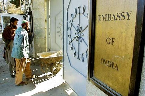 An Afghan labourer pushes a wheelbarrow into the Indian embassy in Kabul.