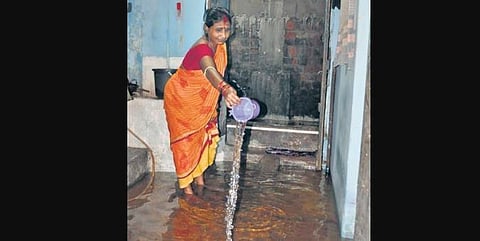 A woman drains out water from her house in Sutahat locality of Cuttack on Tuesday | Rashmiranjan Mohapatra
