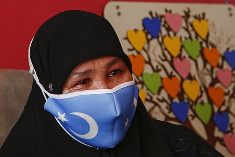 Bumeryem Rozi, 55, an ethnic Uyghur who fled from China to Turkey, cries as she talks to The Associated Press, at her home, in Istanbul (File Photo | AP)