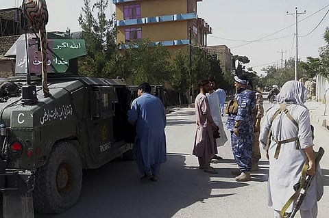 Afghan security personnel stand guard along a road amid ongoing fight between Afghan security forces and Taliban fighters in city of Qala-i- Naw, the capital of Badghis province. (Photo | AFP)