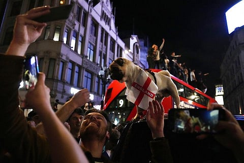 Fans celebrate by taking a selfie with a dog after England won the Euro 2020 soccer championship semifinal match between England and Denmark. (Photo | AP)