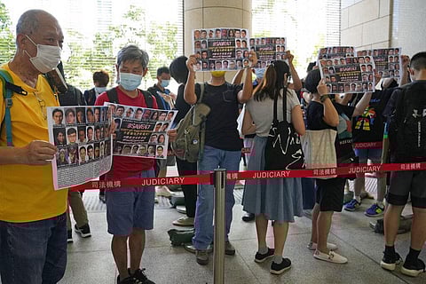 Supporters hold placards with the photos of some of the 47 pro-democracy defendants outside a court in Hong Kong, Thursday, July 8, 2021. (Photo | AP)