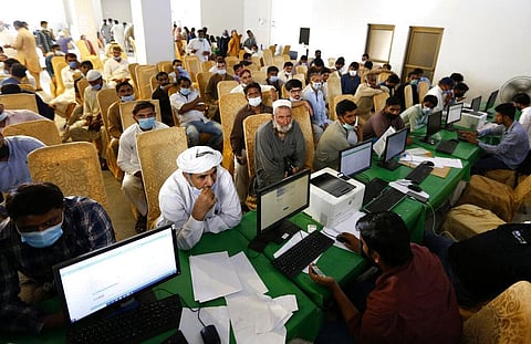 Heath workers register expatriate workers before they can be vaccinated with Moderna COVID-19 vaccine at a vaccination center, in Lahore, Pakistan, Tuesday, July 6, 2021. (Photo | AP)