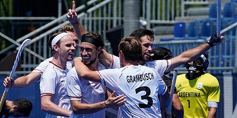Germany players embrace Lukas Windfeder, right, after scoring against Argentina during a men's field hockey match at the 2020 Summer Olympics, in Tokyo, Japan. (Photo | AP)