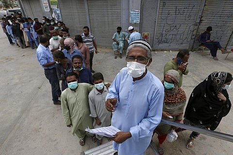 People line up in front a mobile vaccination van to receive shots of the Sinovac COVID-19 vaccine, in Karachi. (Photo | AP)