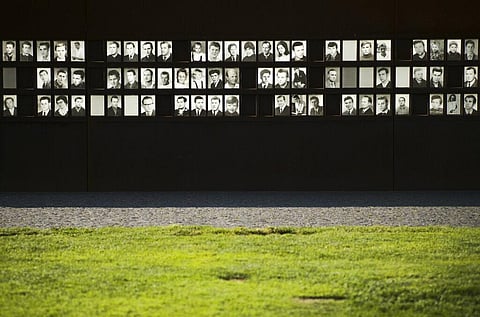 Photos of victims of the Berlin Wall are illuminated by the sun at the Wall memorial at Bernauer Strasse at the eve 60th anniversary of the construction of the Berlin Wall. (Photo | AP)