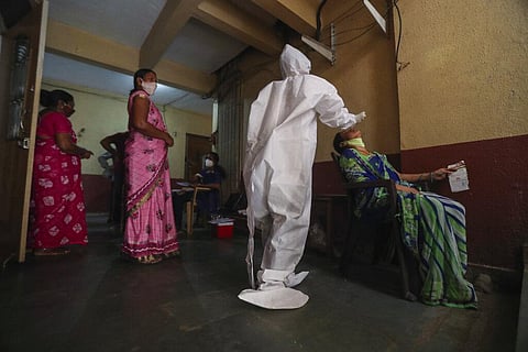 A health worker collects swab samples during a door-to-door screening for COVID-19 people at Dharavi. (Photo | AP)