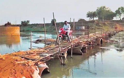 A biker crosses Indravati river on the makeshift bridge in Chirma. (Photo | Express)