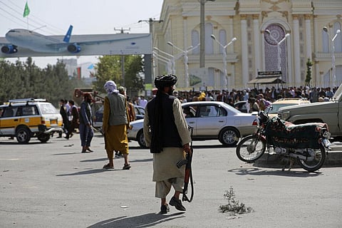 Taliban fighters stand guard in front of the Hamid Karzai International Airport, in Kabul. (Photo | AP)