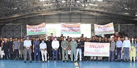 Indian embassy staff working in Kabul, pose for a group photograph on their arrival at the Air force base, in Jamnagar. (Photo| AP)
