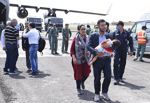 An Indian embassy staff member with his family arrives at Air force base, in Jamnagar. (Photo | AP)