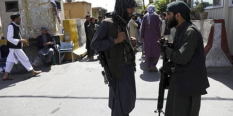 Taliban fighters stand guard in front of the main gate leading to Afghan presidential palace in Kabul, Afghanistan. (Photo | AP)