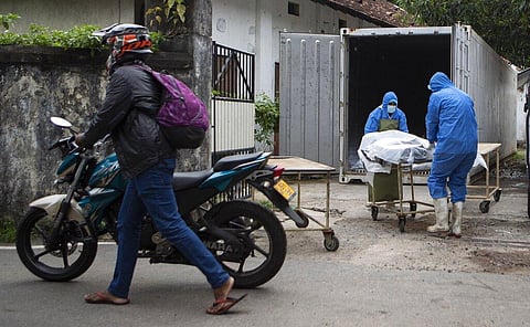 Sri Lankan health workers transport the dead body of a person to test for COVID-19 before handing over them to families in Colombo. (Photo | AP)