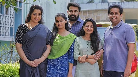A still from 'Drishyam 2' starring Mohanlal and Meena in the lead roles along with filmmaker Jeethu Joseph.