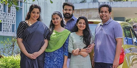 A still from 'Drishyam 2' starring Mohanlal and Meena in the lead roles along with filmmaker Jeethu Joseph.