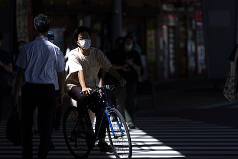 People wearing masks to help stop the spread of the coronavirus walk across an intersection in Tokyo. (Photo | AP)