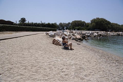 A woman drinks water during a heatwave at a beach, in Alimos suburb, southern Athens, Greece, Monday, Aug. 2, 2021. (Photo | AP)