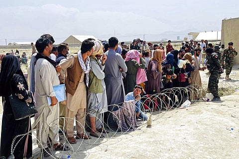 Afghan security guards try and maintain order as hundreds of people gather outside the international airport in Kabul, Afghanistan. (Photo | AP)